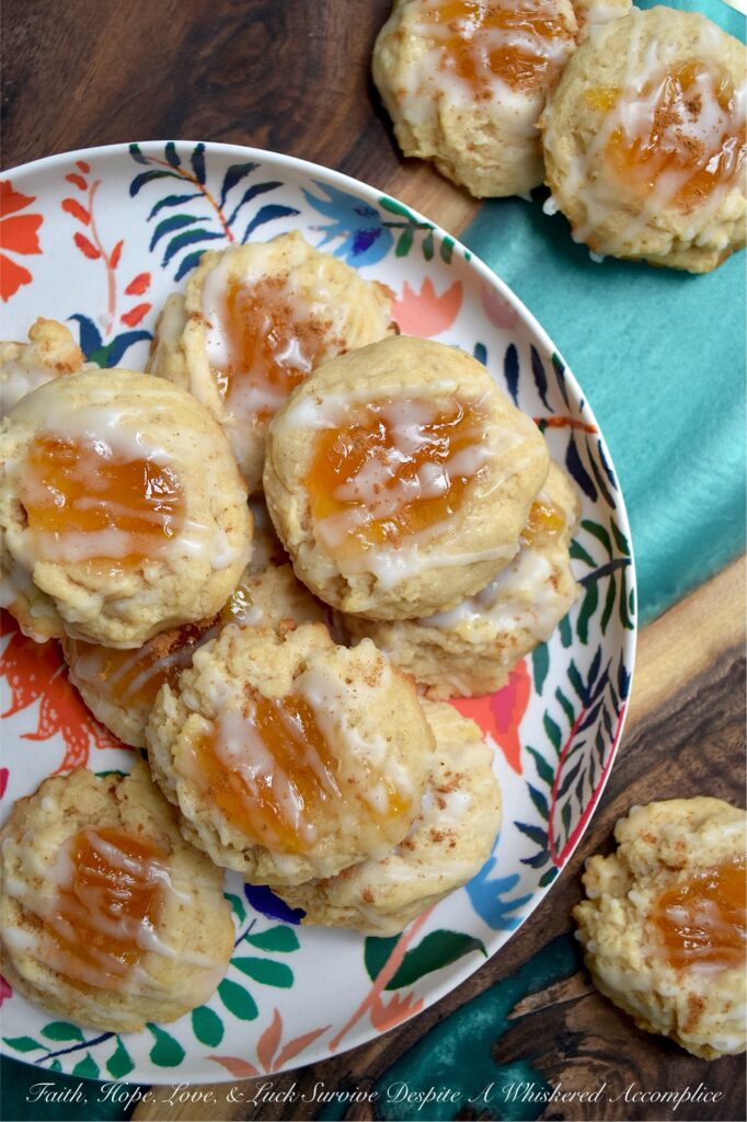 Peaches and Cream Rustic Thumbprint Cookies - Craving a taste of summer all year long? These buttery, fruity cream cheese thumbprint cookies are pretty much sunshine in a bite. With a gooey peach preserves center, a splash of peach schnapps in the icing, and enough cinnamon warmth to add just the right amount of spice, these peaches and cream rustic thumbprint cookies are addictively dangerous. Whether you’re pairing them with morning coffee or evening tea, these jammy cookies are proof that summer never really has to end.