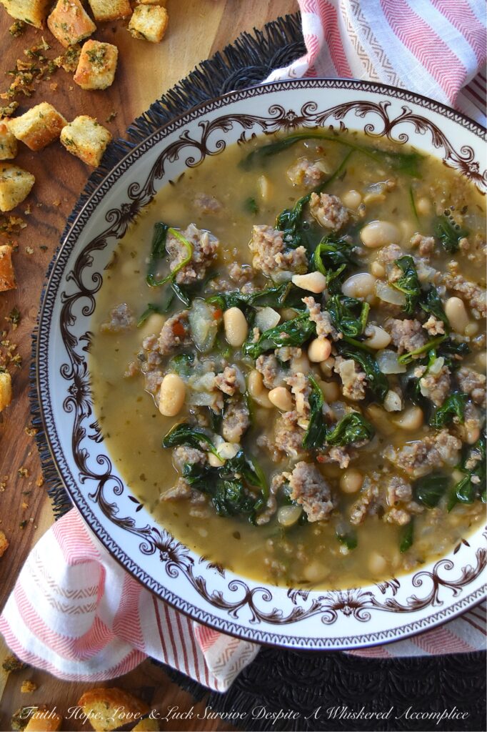 Weeknight Italian Sausage & Spinach Bean Soup - Loaded with savory mild Italian sausage, creamy canned beans, and tender baby spinach, this Italian herb-infused soup is simple to make, budget-friendly, and easy to adapt. You can use homemade or store-bought chicken broth, or even add more vegetables like carrot, butternut squash, or sweet potato. Finish this bean soup with a generous sprinkle of freshly grated Parmesan or a handful of crunchy, simple homemade baked croutons for an effortless one-pot meal that turns a chaotic weeknight into a cozy night in.