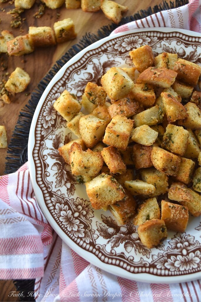 Simple Baked Olive Oil Croutons with Parmesan - Forget tossing out rock-hard baguettes or leftover dinner rolls. With a generous drizzle of olive oil, a few everyday savory seasonings, and a generous sprinkle of nutty, salty Parmesan cheese, you can easily transform yesterday's stale bread into golden, crispy, flavor-packed croutons in minutes. Whether you’re tossing these simple baked croutons into a crisp salad or drowning them in a cozy bowl of soup, these homemade gems are so irresistibly crunchy, you'll find yourself intentionally letting bread go stale just to make them.