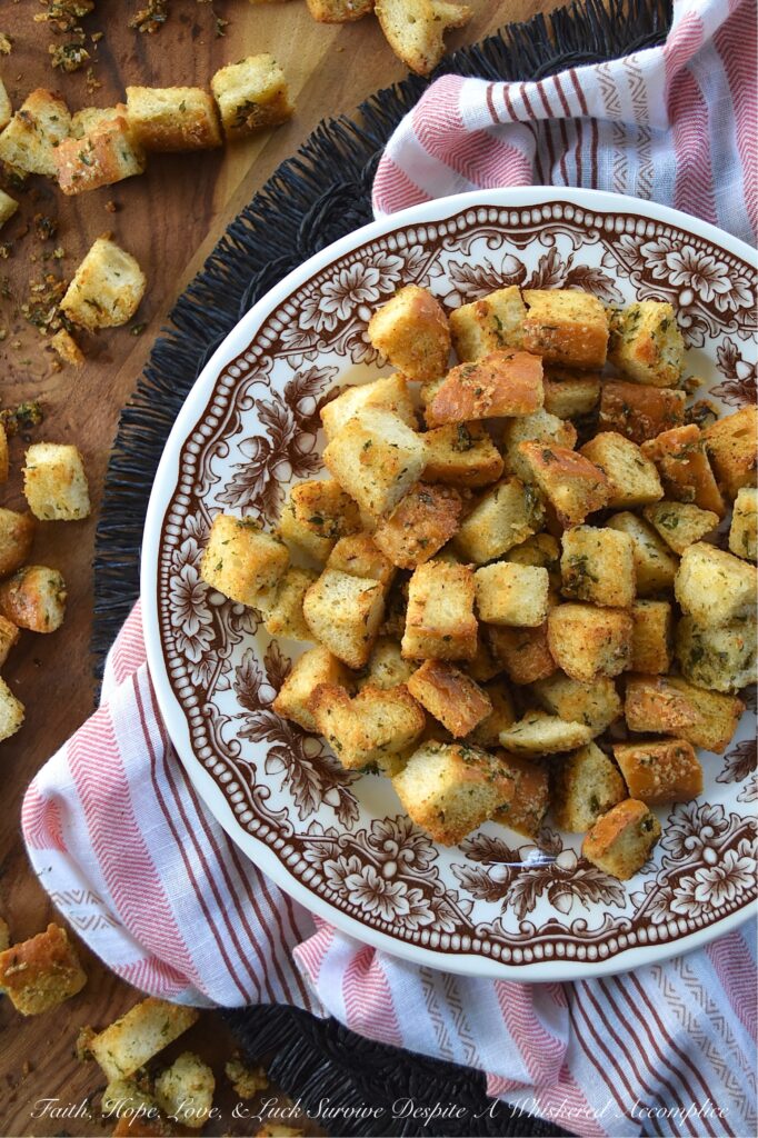 Simple Baked Olive Oil Croutons with Parmesan - Forget tossing out rock-hard baguettes or leftover dinner rolls. With a generous drizzle of olive oil, a few everyday savory seasonings, and a generous sprinkle of nutty, salty Parmesan cheese, you can easily transform yesterday's stale bread into golden, crispy, flavor-packed croutons in minutes. Whether you’re tossing these simple baked croutons into a crisp salad or drowning them in a cozy bowl of soup, these homemade gems are so irresistibly crunchy, you'll find yourself intentionally letting bread go stale just to make them.