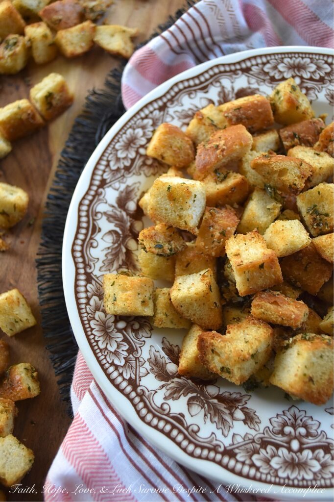 Simple Baked Olive Oil Croutons with Parmesan - Forget tossing out rock-hard baguettes or leftover dinner rolls. With a generous drizzle of olive oil, a few everyday savory seasonings, and a generous sprinkle of nutty, salty Parmesan cheese, you can easily transform yesterday's stale bread into golden, crispy, flavor-packed croutons in minutes. Whether you’re tossing these simple baked croutons into a crisp salad or drowning them in a cozy bowl of soup, these homemade gems are so irresistibly crunchy, you'll find yourself intentionally letting bread go stale just to make them.