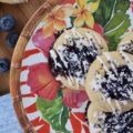 Honey & Balsamic Blueberry Jam Cookies - These buttery summer thumbprint cookies are filled with a slightly sweet homemade saucy honey & balsamic vinegar blueberry jam. After being baked to perfection, they are then lightly garnished with drizzle and a generous amount of sprinkles. These cookies are buttery, sweet, crumbly, and crunchy all at the same time, they're basically the perfect cookie.