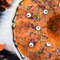 Halloween-Inspired Orange Ricotta Bundt Cake - The secret to this light, moist, and airy Bundt cake is the ricotta cheese it contains, as well as the added orange zest and juice, which help give it a lovely citrus flavor. Topping it with an orange powdered sugar glaze, followed by festive Halloween sprinkles and candy eyeballs, also helps to give this holiday cake the perfect touch of spooky cuteness.