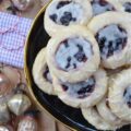 Orange Mixed Berry Glazed Thumbprint Cookies - These gorgeous mixed berry preserves-filled orange thumbprint cookies, topped with a simple orange and vanilla extract powdered glaze, are a delicious treat that combines buttery, sweet, citrusy, and fruity flavors to create a cookie worthy of any cookie tray or platter. Whether you bake these cookies during the holidays or just because you’re craving something sweet, they're guaranteed to be an instant hit with anyone who tries them.